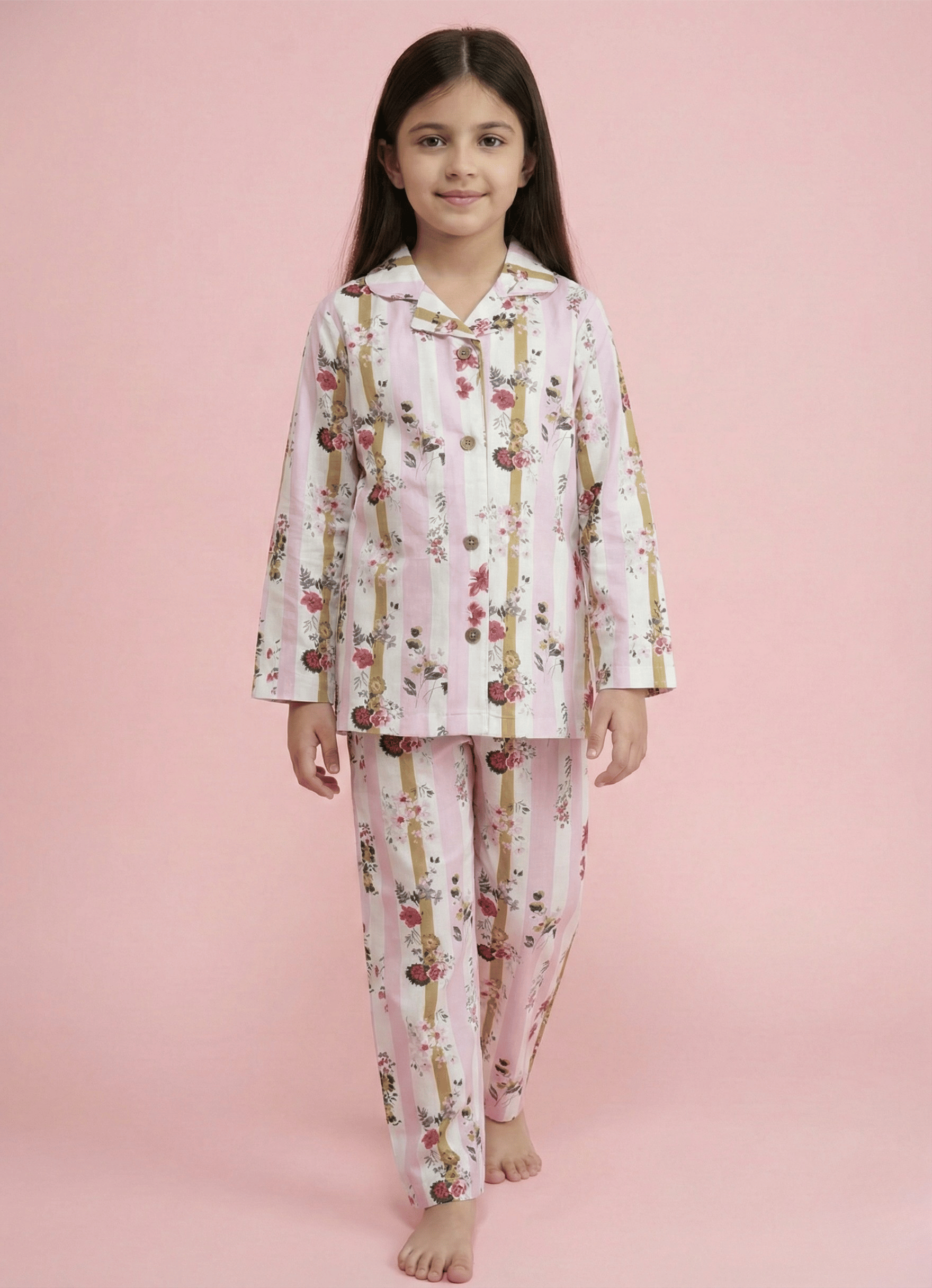 Young girl wearing a floral pajama set on a pink background