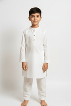 Young boy wearing a white traditional outfit on a white background