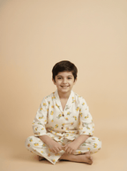 Child wearing a white floral kimono sitting on a beige background
