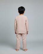 Child wearing a striped pajama set against a plain background