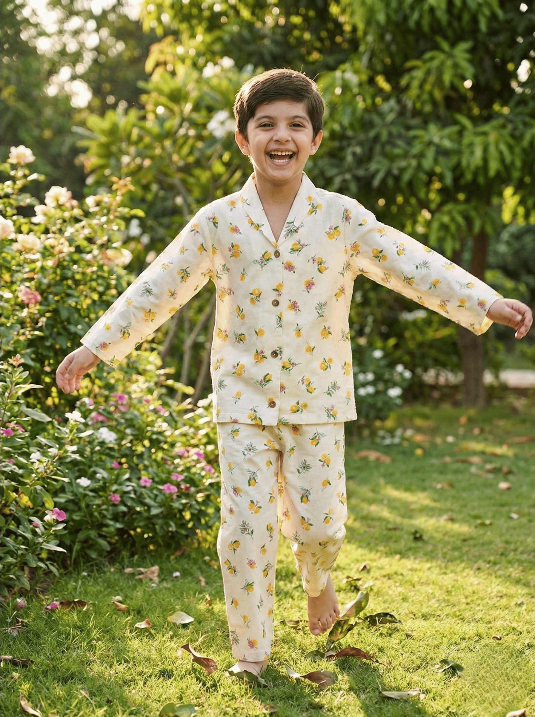 Child in a floral outfit standing in a garden with greenery and flowers in the background